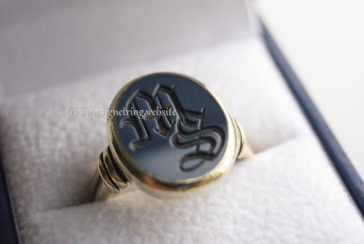 Gold ring with dark blue layered gemstone ms